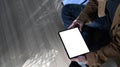 Young man freelance sitting on wooden floor and using digital tablet. Royalty Free Stock Photo