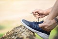 Cropped shot of young man runner tightening running shoe laces, Royalty Free Stock Photo