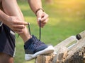 Cropped shot of young man runner tightening running shoe laces, Royalty Free Stock Photo