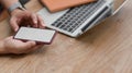 Cropped shot of young man using blank screen smartphone while working on his project with laptop Royalty Free Stock Photo