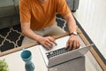 Cropped shot of young man using laptop in the living room. Royalty Free Stock Photo