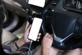 Cropped shot of young woman connecting mobile phone to the car audio system using wireless technology. Royalty Free Stock Photo