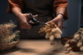 Cropped shot of young woman cutting dried flowers with scissors and arranging bouquet in her flower shop Royalty Free Stock Photo