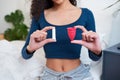 Cropped shot of young woman holding tampon and menstrual cup as comparison Royalty Free Stock Photo