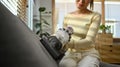 Cropped shot of young woman using handheld cordless vacuum cleaner to vacuuming and cleaning the dust on couch Royalty Free Stock Photo