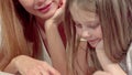 Cropped sliding shot of a mother and daughter reading a book together