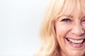 Cropped Studio Shot Of Laughing Mature Woman Against White Background At Camera