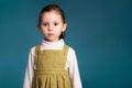 Cropped studio simple portrait of little kid girl 5 y.o. looking at camera over blue background