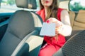 Cropped successful caucasian woman passenger holding blank white card and want to pay taxi fare with credit card. Modern secure