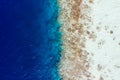 Cropped top above high angle aerial drone view of pure blue ocean water washing seashore stones coral reef wild Royalty Free Stock Photo