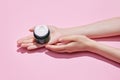Cropped top view of female hands holding black jar of cream, night cream in hands. Using cosmetics product isolated Royalty Free Stock Photo