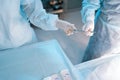 Cropped top view of unrecognizable assistant in surgical uniform assists surgeons, giving medical instruments during Royalty Free Stock Photo