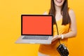 Cropped tourist woman holding laptop pc computer with blank black empty screen isolated on yellow orange background Royalty Free Stock Photo