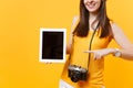 Cropped tourist woman holding tablet pc computer with blank black empty screen isolated on yellow orange background