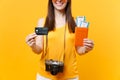 Cropped tourist woman in summer casual clothes holding credit card, passport tickets isolated on yellow orange
