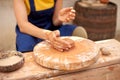 Cropped unrecognizable ceramist woman working with potter`s wheel in cozy workshop