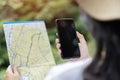 Cropped unrecognizable woman traveler using smartphone browsing on map app standing on slope of amazing landscape