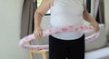 Cropped view of active senior woman playing hula hooping in the livingroom at home