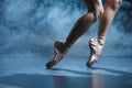 cropped view of ballerina dancing in pointe shoes in dark studio Royalty Free Stock Photo