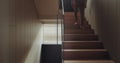 Cropped view on barefoot man go upstair on second floor of modern house