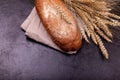 Cropped view of brown loaf on stone black surface. Rye bread on dark Royalty Free Stock Photo