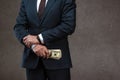 View of businessman holding dollar banknotes in hand on grey Royalty Free Stock Photo