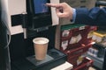 A man buys coffee from a coffee machine. cropped view of businessman pushing button on coffeemaker while preparing Royalty Free Stock Photo