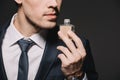 Cropped view of businessman smelling perfume isolated