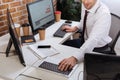 young businessman sitting near computers, smartphone