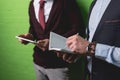 cropped view of businessmen working with digital tablet and notepad in front of