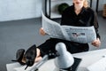 Cropped view of businesswoman in black clothes sitting at table and