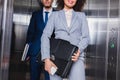 Cropped view of businesswoman with briefcase and man with folders standing Royalty Free Stock Photo