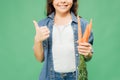 Cropped view of child holding carrots and showing thumb up sign isolated Royalty Free Stock Photo
