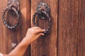 cropped view of child knocking in door with metal handle