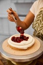 Cropped view of confectioner putting berry