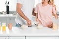 View of couple with bowls of cereal during breakfast at kitchen