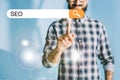 cropped view of developer in checkered shirt pointing SEO Royalty Free Stock Photo