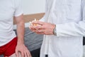 Doctor holding anatomical human bone model, during physiotherapy session with male patient