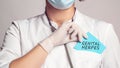 Cropped view of doctor in a white coat and sterile gloves holding a note with words - GENITAL HERPES