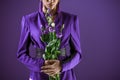 Cropped view of fashionable girl posing in suit with bouquet of flowers, Royalty Free Stock Photo