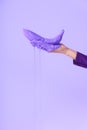 cropped view on female hand holding banana in purple paint, isolated on ultra violet Royalty Free Stock Photo