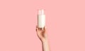 Cropped view of female hand holding glass of fresh milk on pink background Royalty Free Stock Photo