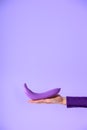 cropped view on female hand holding purple banana, Royalty Free Stock Photo