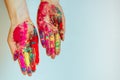 Cropped view of female hands with multicolored holi powder, on white background. Bright colors holi on palms, copy space. Concept Royalty Free Stock Photo