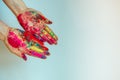 Cropped view of female hands with multicolored holi powder, on white background. Bright colors holi on palms, copy space. Concept Royalty Free Stock Photo