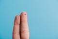 cropped view of fingers as dissatisfied couple isolated on blue.