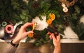 Cropped view of florist hands making Christmas wreath