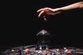 Cropped view of fortuneteller hand above crystal ball with fortune telling stones on black velvet cloth