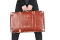 Cropped view of girl in jeans holding vintage suitcase isolated on white. Royalty Free Stock Photo