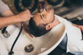 Cropped view hairstylist washing clients hair in barber Royalty Free Stock Photo